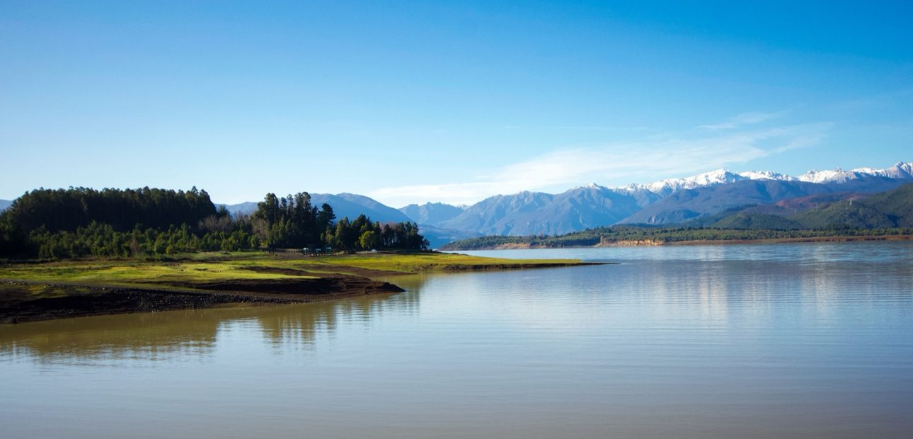 Vista panoramica del Lago Colbun con la cordillera nevada al fondo, en la ribera norte donde se emplaza Costa Cantera
