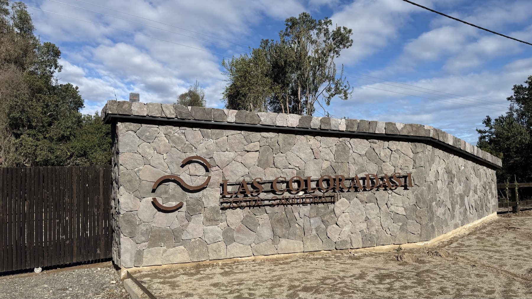 Portal de piedra del acceso al sector Las Coloradas I del condominio Costa Cantera, en el Lago Colbún